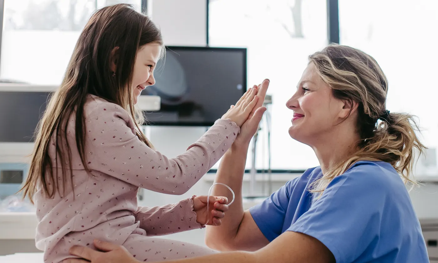 Fellow speaking with a child in ER