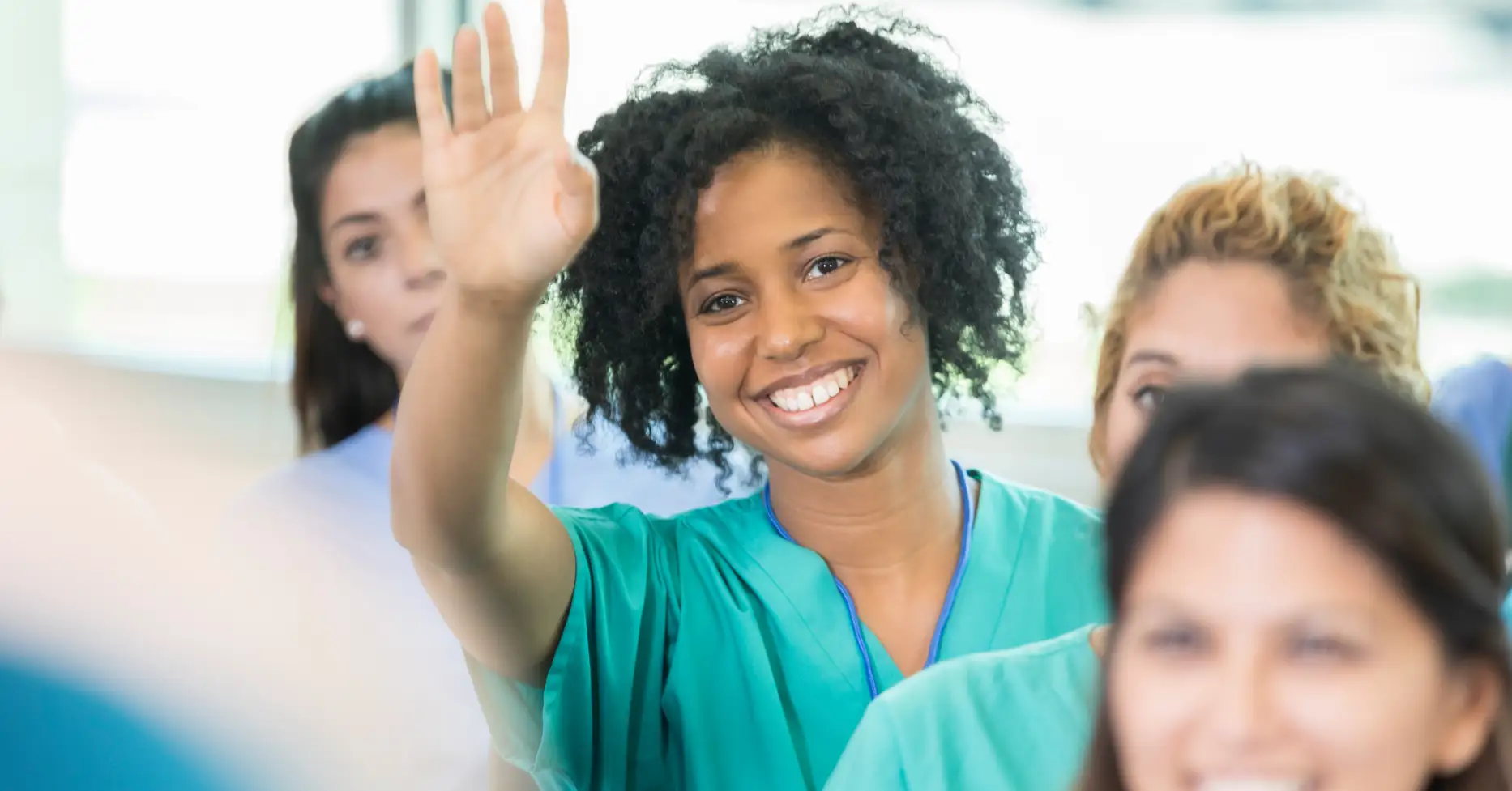 Nurse in class raising hand to ask question
