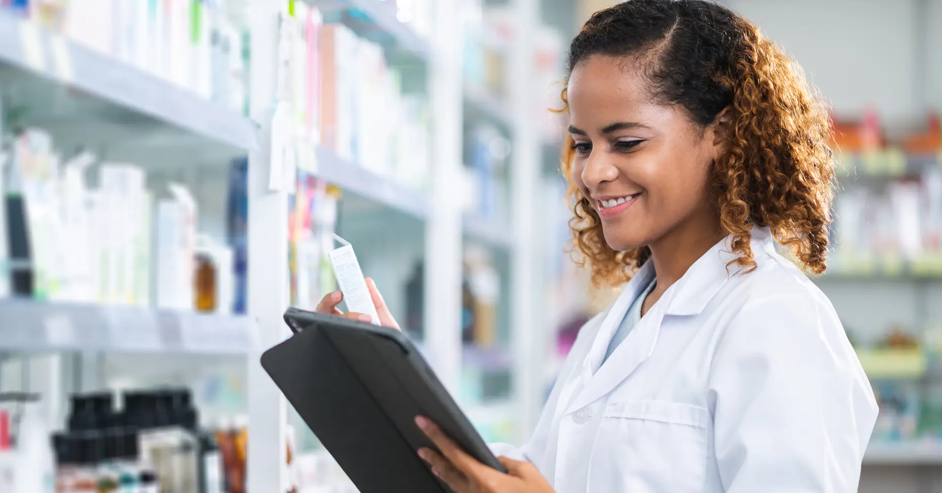 Pharmacist checking inventory on shelves in pharmacy