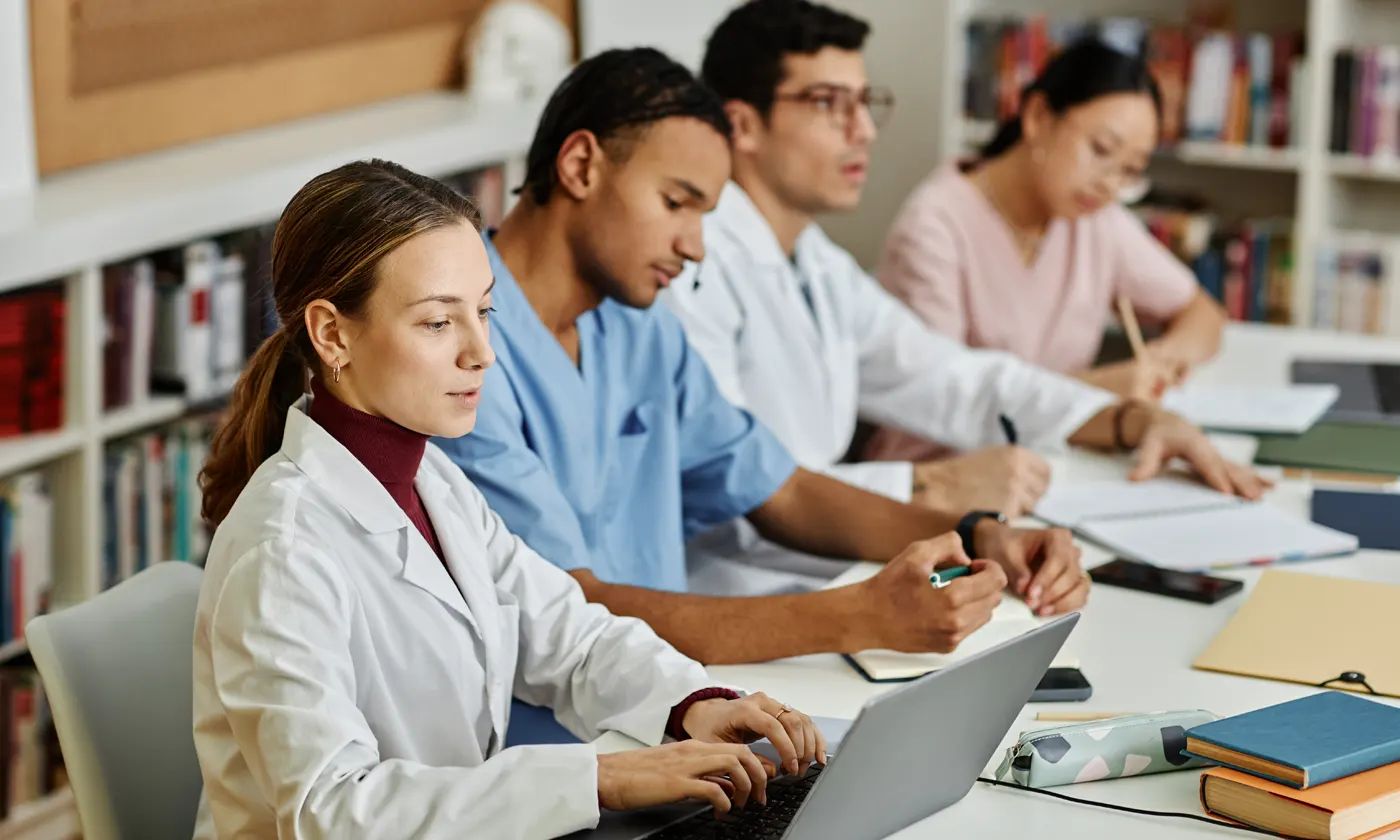 Nursing students doing research at desk on various class projects