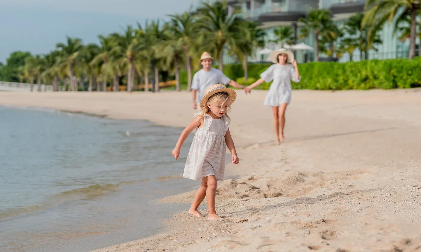 family walking on beautiful Florida beach on a sunny day
